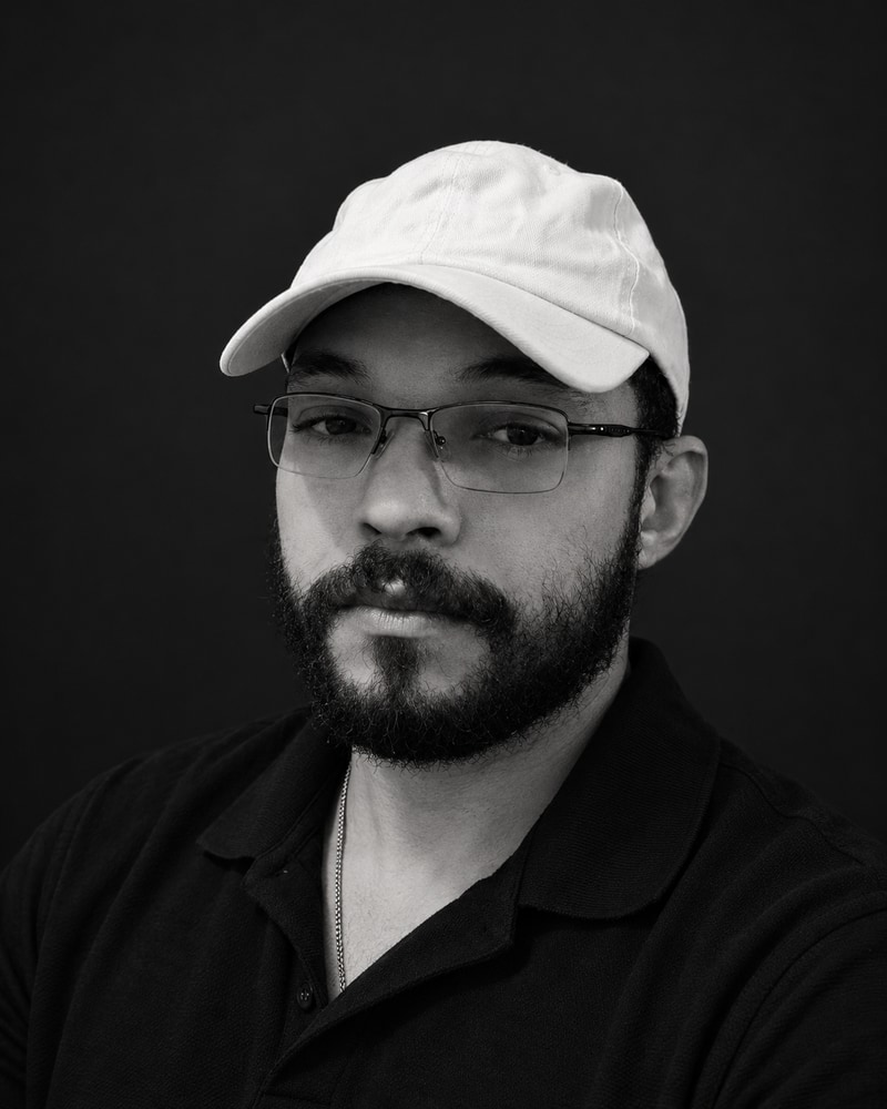 João Lucas Balan, de boné branco, óculos e camisa polo preta
